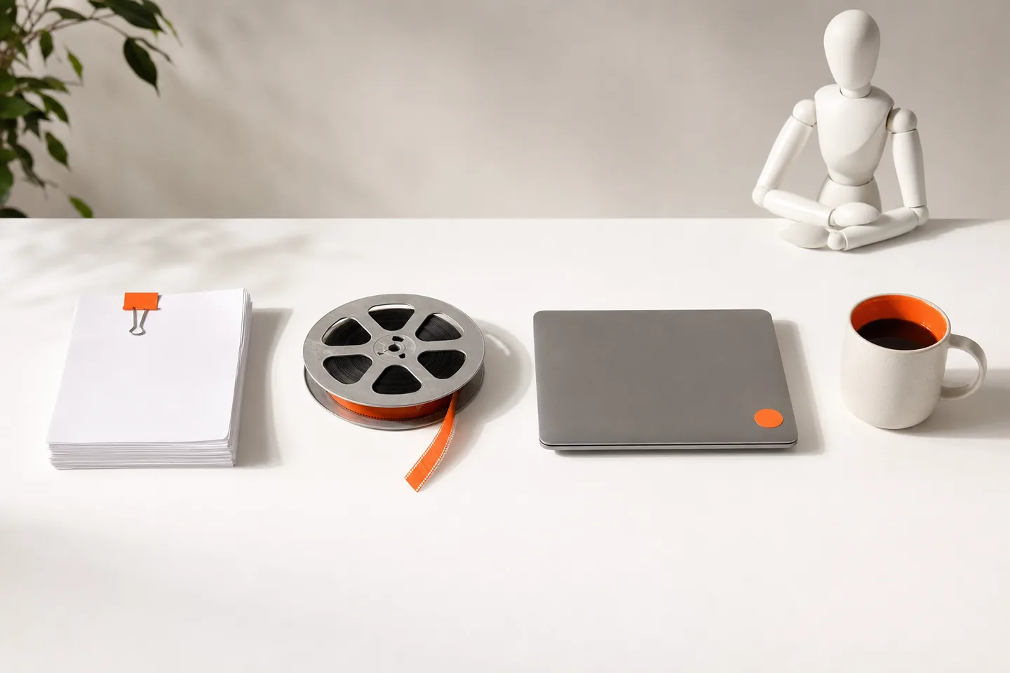 Four orange objects in a row on a white table, each a different shape