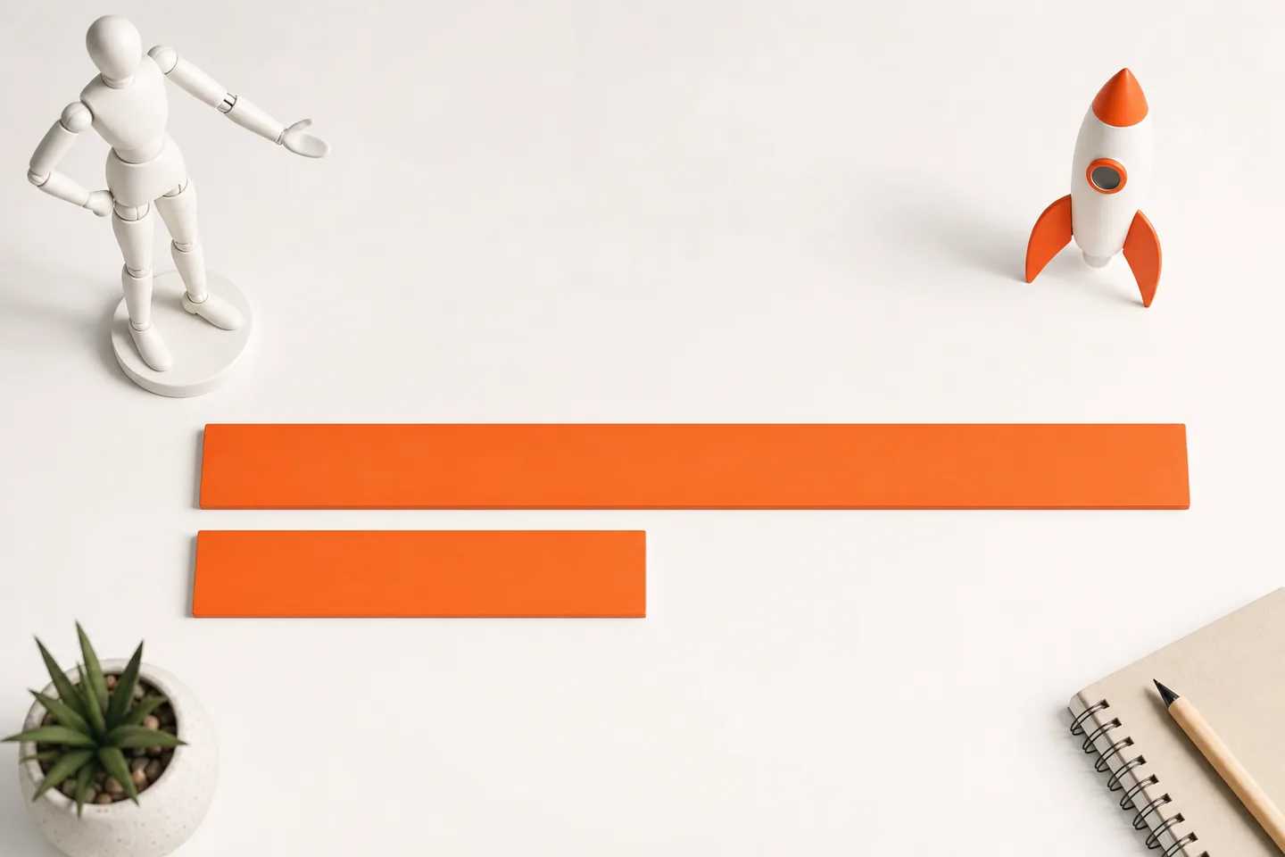 Two orange measuring rulers of very different lengths lying side by side on a bright white surface