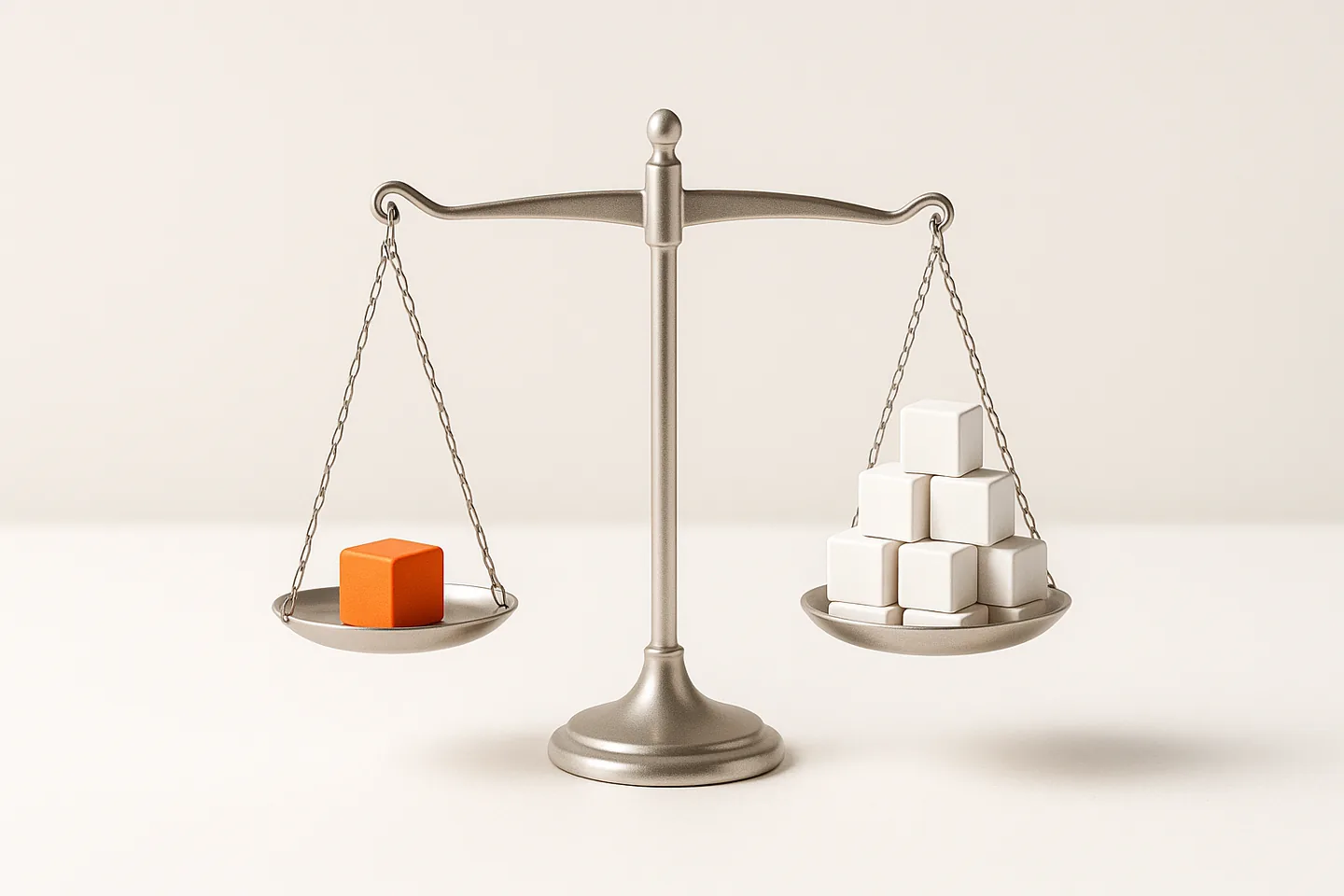 A metal balance scale on a bright surface with one orange cube on the left pan and a stack of white cubes on the right